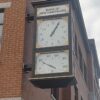 Close-up view of the McClintock-style clock at the Bank of New Hampshire, featuring a time dial and thermometer.