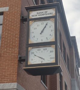 Close-up view of the McClintock-style clock at the Bank of New Hampshire, featuring a time dial and thermometer.