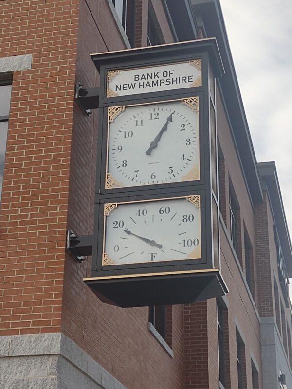 Close-up view of the McClintock-style clock at the Bank of New Hampshire, featuring a time dial and thermometer.