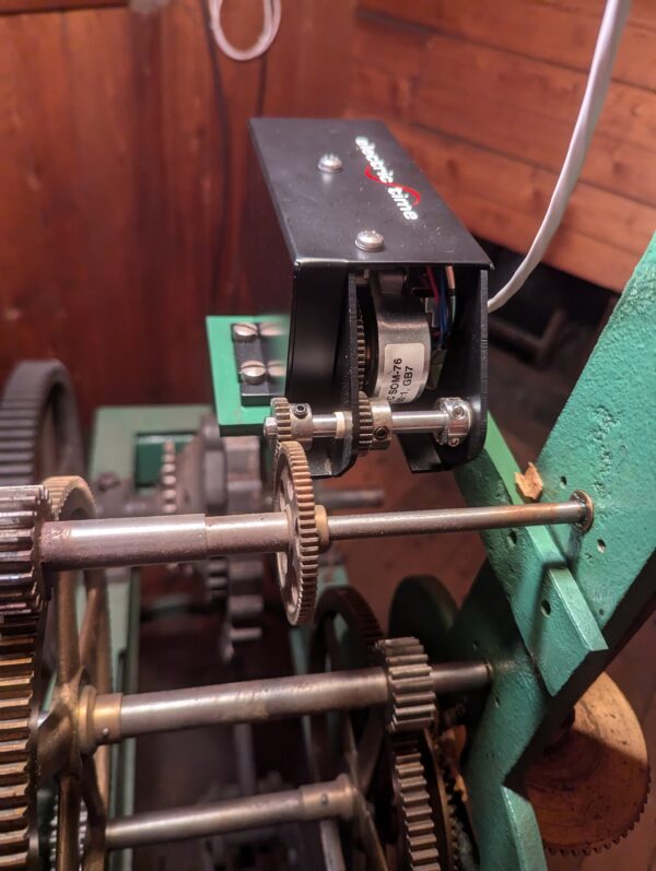 Close-up of a Bodine motor mounted on a vintage clock assembly, showing gears and mechanical connections